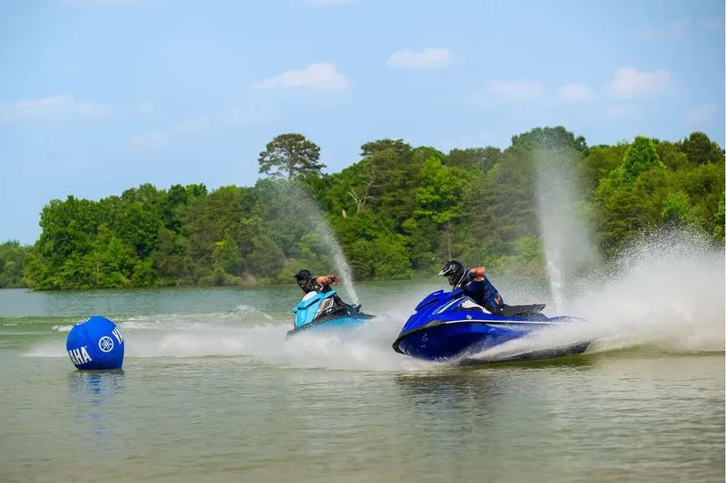 Slide: The Image of 2024 Yamaha WaveRunner GP SVHO jet skis racing on a lake with lush green trees. - 9