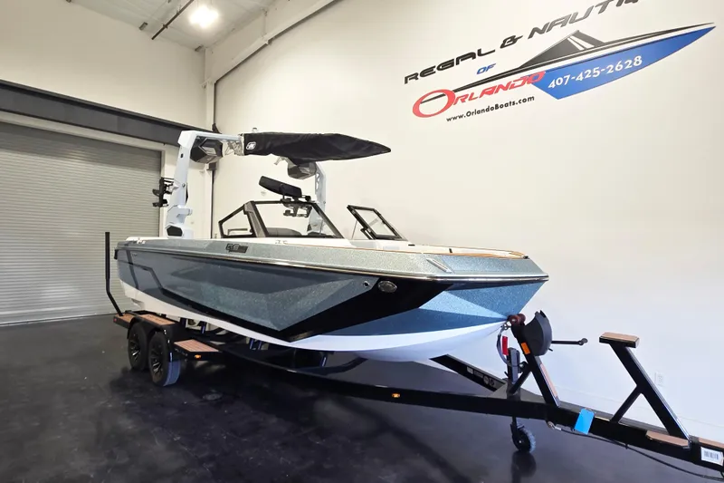 Slide: The Image of 2026 Nautique Super Air Nautique GS22 boat on trailer in showroom. - 2