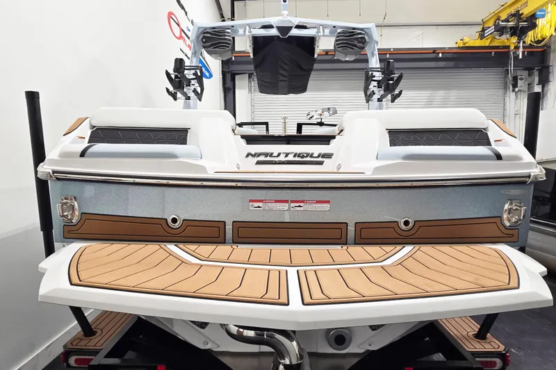 Slide: The Image of 2026 Nautique Super Air Nautique GS22 boat, rear view in showroom setting. - 4