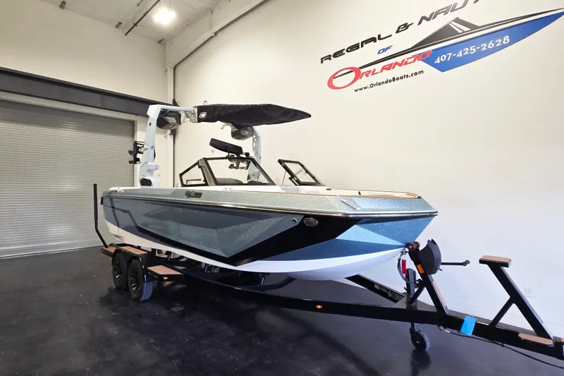 The Image of 2026 Nautique Super Air Nautique GS22 boat on trailer in showroom. - 1