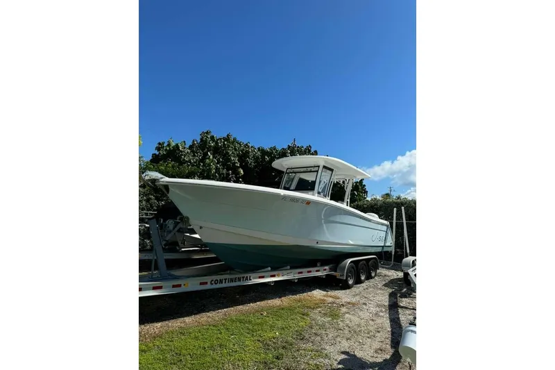 The Image of 2017 Robalo R302 Center Console boat on trailer under clear blue sky. - 1