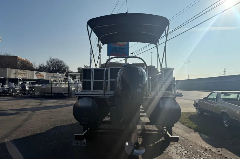 Slide: The Image of 2020 Lund LX220 Pontoon Fish boat with canopy in a parking lot. - 1