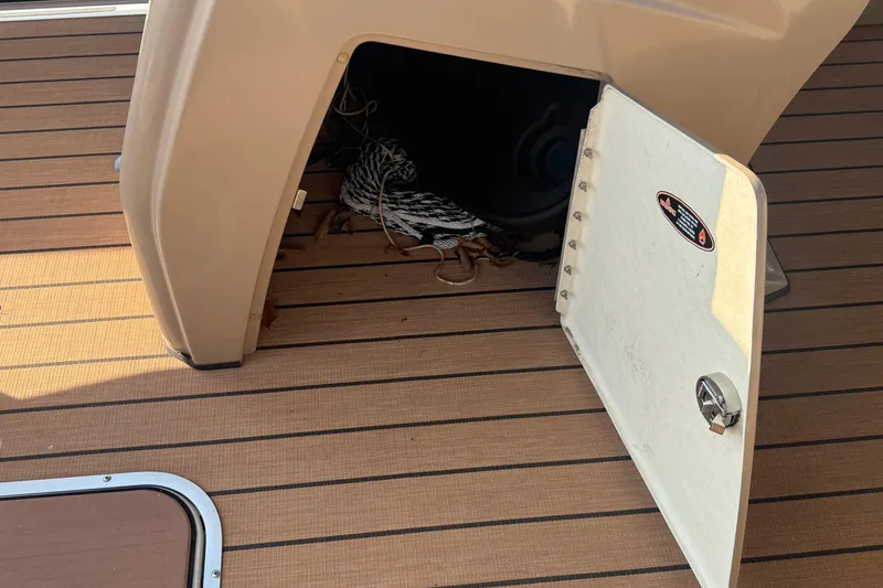 Slide: The Image of Open storage compartment on 2020 Lund LX220 Pontoon Fish boat with rope inside. - 13