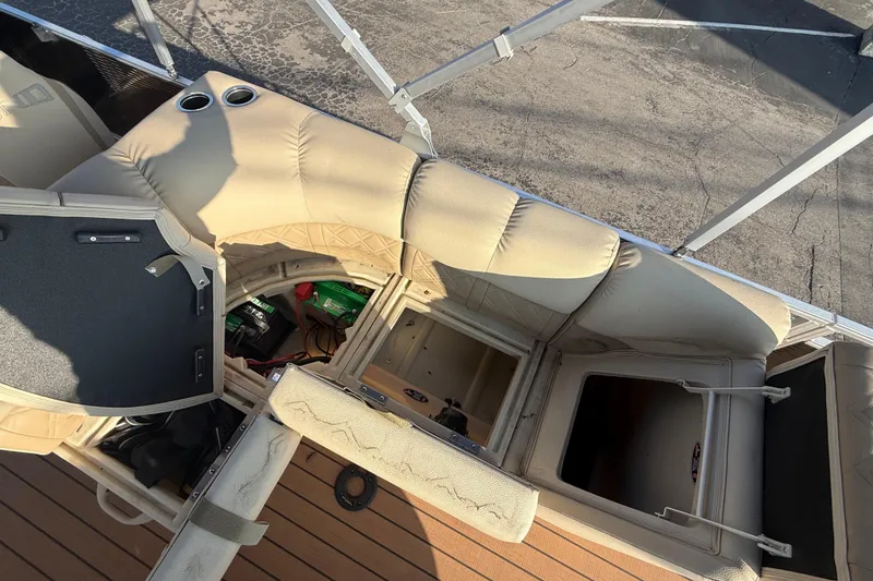 Slide: The Image of 2020 Lund LX220 Pontoon Fish interior with beige seating and storage compartments. - 7