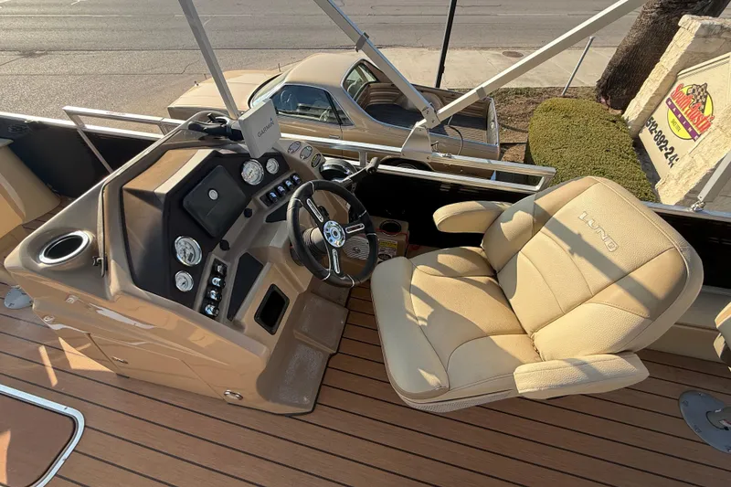 Slide: The Image of 2020 Lund LX220 Pontoon Fish boat interior with steering console and beige captain's chair. - 8
