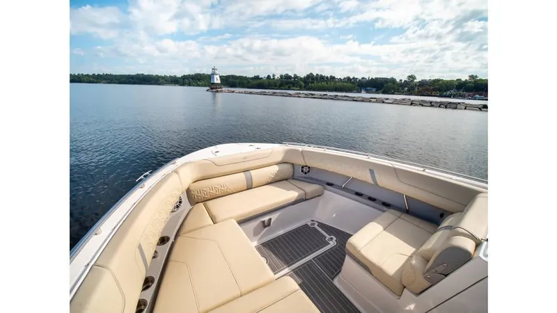 Slide: The Image of 2022 Regal LS36 boat with luxurious seating on a serene lake. - 10