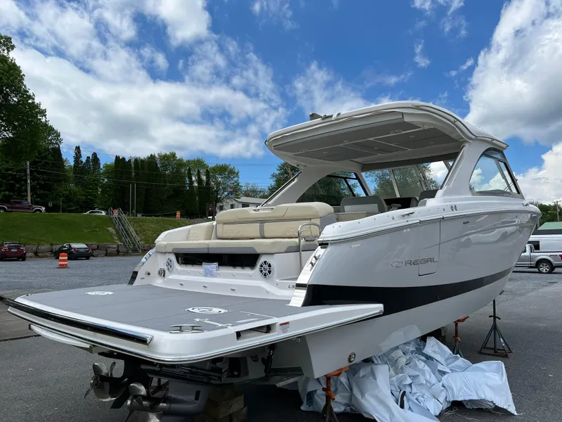 Slide: The Image of 2022 Regal LS36 boat with spacious deck, parked outdoors under a blue sky. - 21