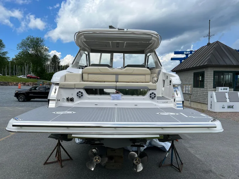 Slide: The Image of 2022 Regal LS36 boat with spacious deck and seating, parked outdoors. - 23