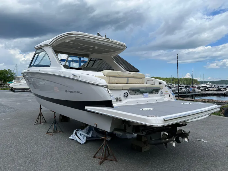 Slide: The Image of 2022 Regal LS36 boat on stands, marina background, cloudy sky. - 24