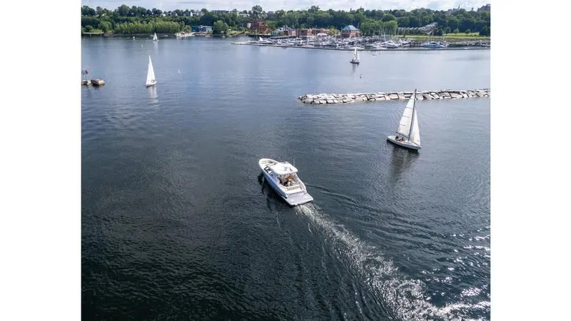 Slide: The Image of Aerial view of 2022 Regal LS36 boat cruising on a serene lake with sailboats nearby. - 3