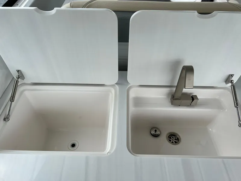 Slide: The Image of Dual sinks with covers on a 2022 Regal LS36 boat. - 35