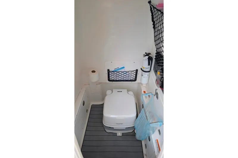 Slide: The Image of 2021 Caymas 26 HB boat interior with portable toilet and storage compartments. - 10