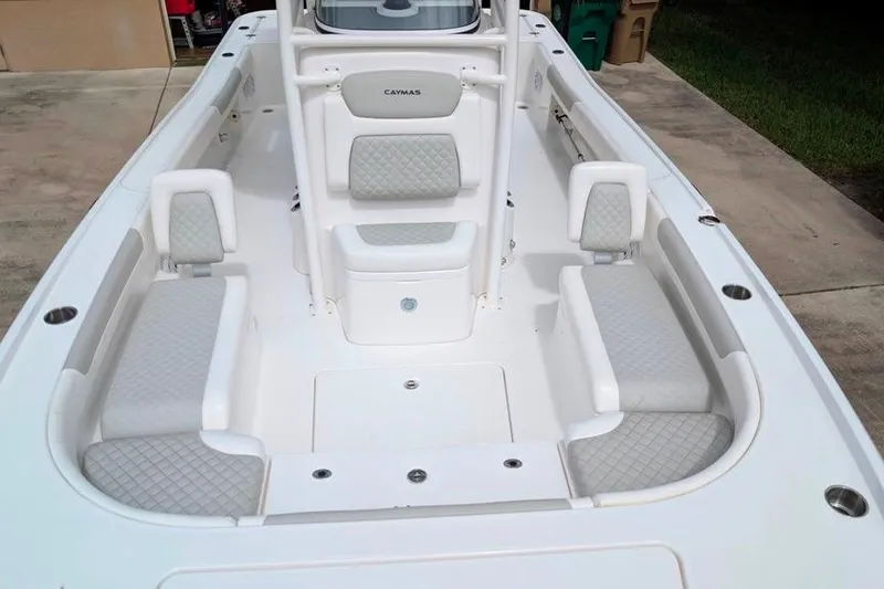 Slide: The Image of 2021 Caymas 26 HB boat interior with cushioned seating and center console. - 13