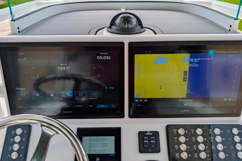 Slide: The Image of 2021 Caymas 26 HB boat dashboard with dual Garmin displays and compass. - 5