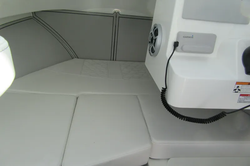 Slide: The Image of 2026 Parker 227 Explorer Sport Cabin interior with cushioned seating and Garmin equipment. - 13