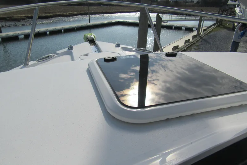 Slide: The Image of 2026 Parker 227 Explorer Sport Cabin boat deck with reflective hatch and water view. - 18
