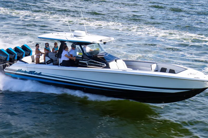 The Image of 2024 Nor-Tech 400 Supersport boat cruising on water with passengers onboard. - 0