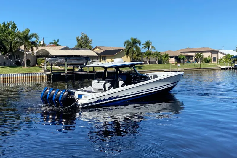 Slide: The Image of 2024 Nor-Tech 400 Supersport boat with quad engines on a sunny waterfront. - 1