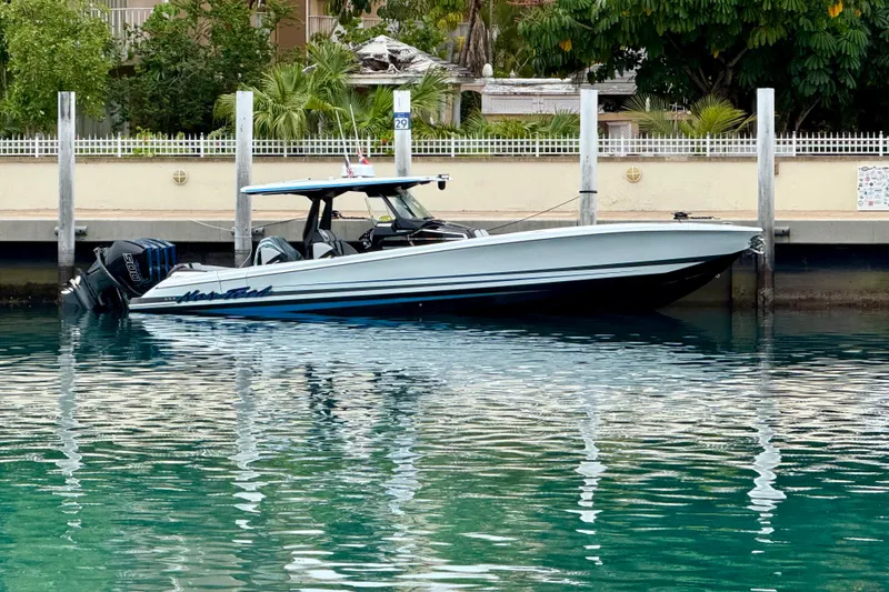 Slide: The Image of 2024 Nor-Tech 400 Supersport boat docked in clear turquoise water. - 3