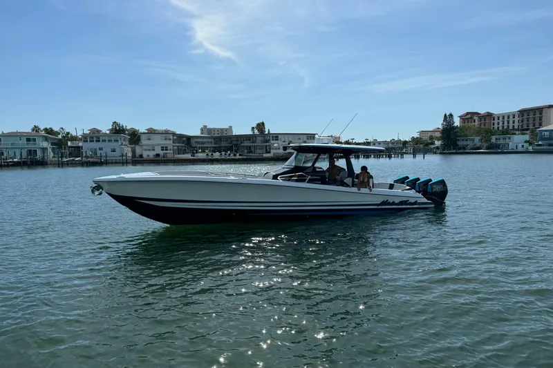 Slide: The Image of 2024 Nor-Tech 400 Supersport boat on calm water, with buildings in the background. - 5