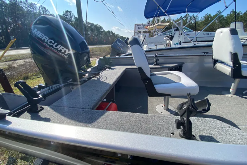 Slide: The Image of 2013 Crestliner 16 SC boat with Mercury engine and seating, parked outdoors. - 8
