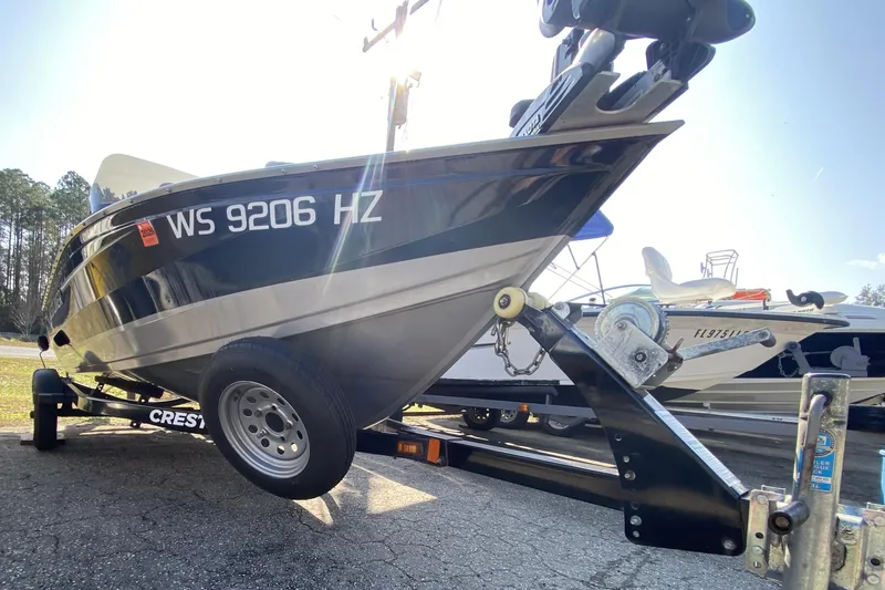 Slide: The Image of 2013 Crestliner 16 SC boat on trailer, parked outdoors, with visible registration number. - 9