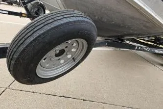 Slide: The Image of 2012 Lund 1600 Fury Tiller boat trailer tire on pavement. - 8