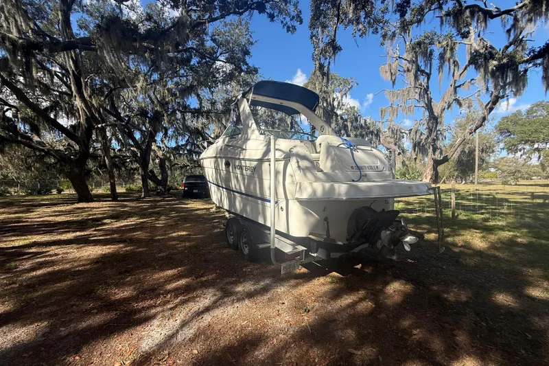 Slide: The Image of 2004 Monterey 265 Cruiser interior with white seating and storage compartments. - 11