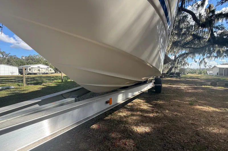 Slide: The Image of 2004 Monterey 265 Cruiser boat interior with seating and helm, docked outdoors. - 12