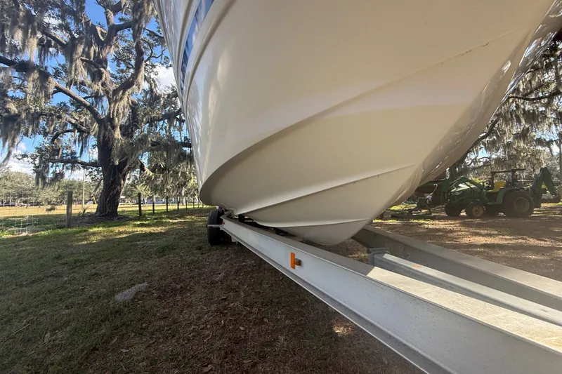 Slide: The Image of 2004 Monterey 265 Cruiser interior with white seating and dashboard, displayed outdoors. - 14