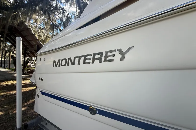 Slide: The Image of Interior view of a 2004 Monterey 265 Cruiser boat, showing cabin entrance and seating. - 21