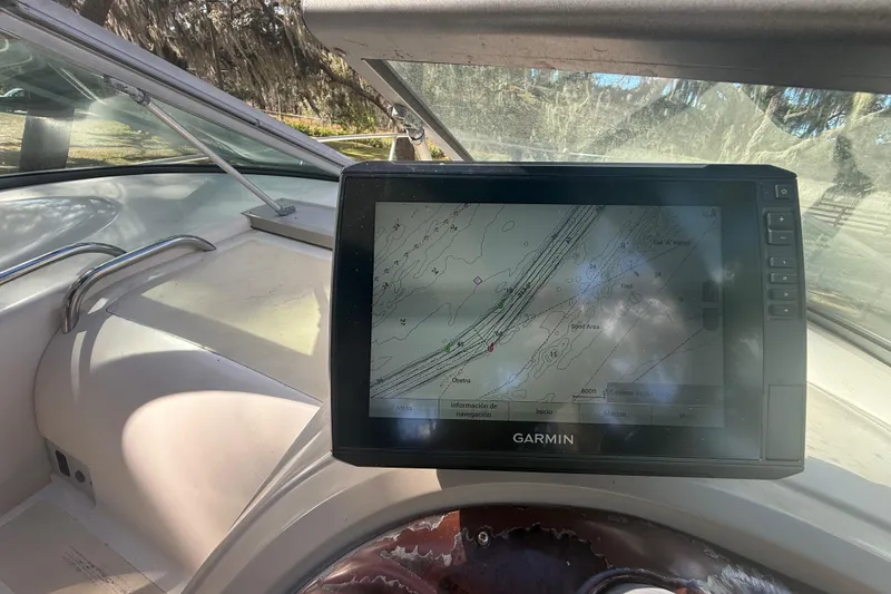 Slide: The Image of 2004 Monterey 265 Cruiser interior with white seating and steering wheel, parked outdoors. - 45