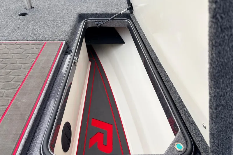 Slide: The Image of 2025 Ranger Z521R Cup-Equipped boat storage compartment with red accents and carpeted interior. - 22