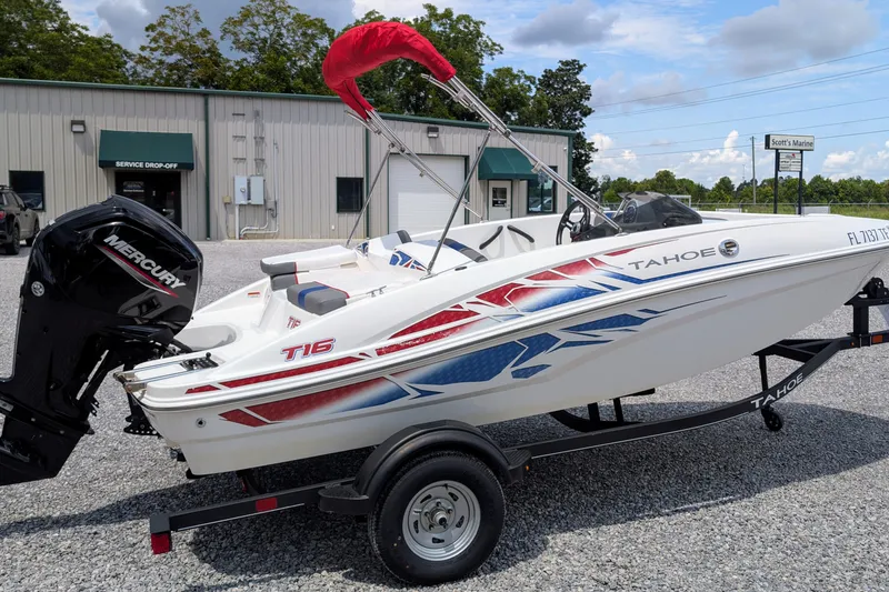 Slide: The Image of 2022 Tahoe T16 boat with Mercury engine on trailer, parked outside service center. - 2
