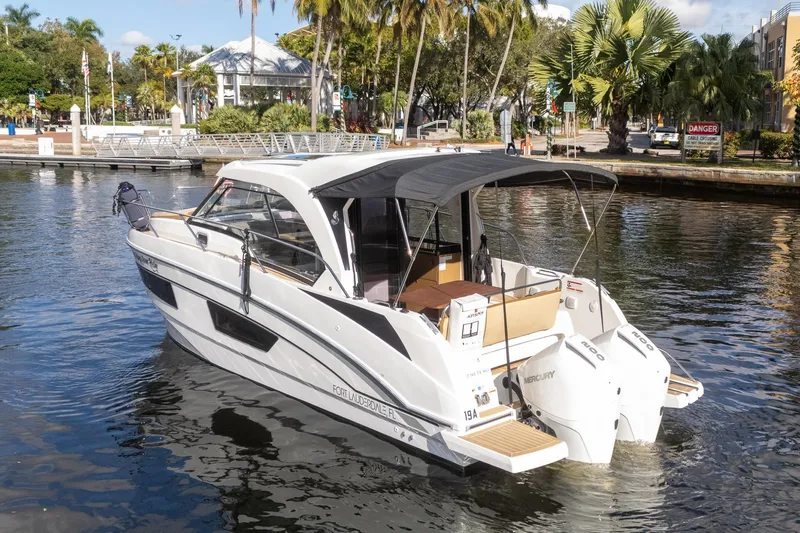 The Image of 2021 Beneteau Antares 9 boat docked in a scenic marina setting. - 1