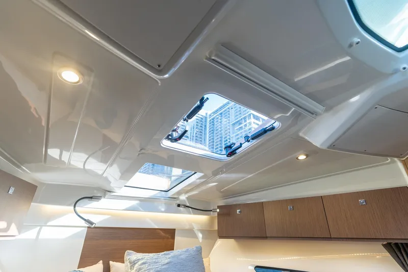 Slide: The Image of Interior view of 2021 Beneteau Antares 9 cabin with skylight and modern lighting. - 14