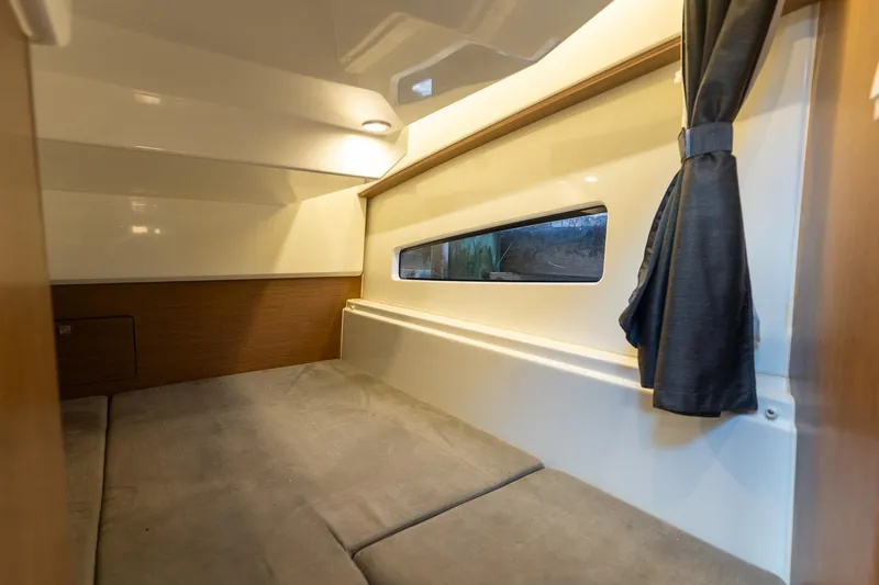 Slide: The Image of Interior cabin of 2021 Beneteau Antares 9, featuring cozy sleeping area and window. - 16