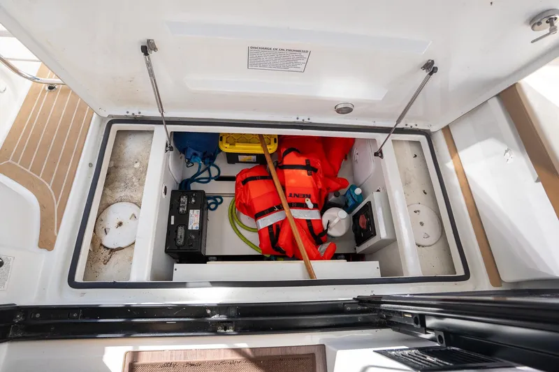 Slide: The Image of Storage compartment of a 2021 Beneteau Antares 9 boat with safety gear and equipment. - 17
