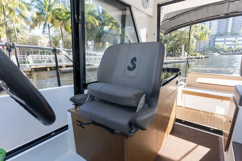 Slide: The Image of Interior of 2021 Beneteau Antares 9 boat with helm seat and scenic waterway view. - 26
