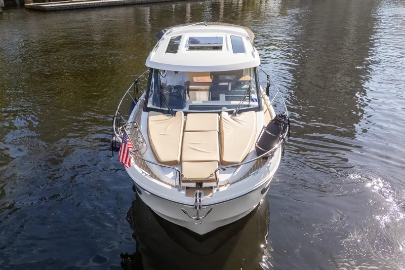 Slide: The Image of 2021 Beneteau Antares 9 boat on water, front view with American flag. - 6