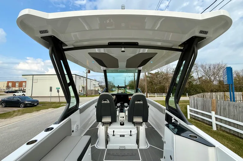 Slide: The Image of 2026 Monterey Elite 25 OB boat interior with modern seating and sleek design. - 12