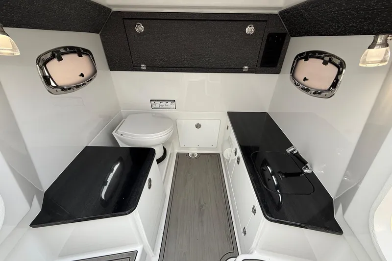 Slide: The Image of Luxurious bathroom interior of 2026 Monterey Elite 25 OB boat with sleek black countertops. - 17