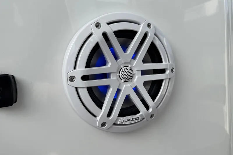 Slide: The Image of White JL Audio speaker with blue lighting on a 2026 Monterey Elite 25 OB boat. - 21