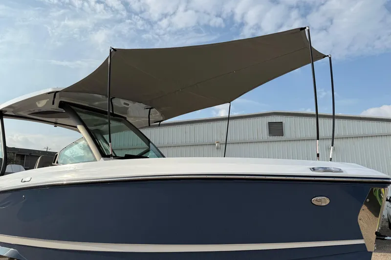 Slide: The Image of 2026 Monterey Elite 25 OB boat with canopy, docked under a cloudy sky. - 23