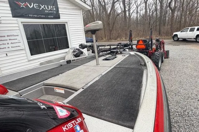 Slide: The Image of 2008 Ranger Z20 Comanche boat parked near Vexus Boats building, surrounded by trees. - 6