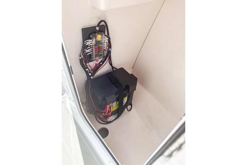 Slide: The Image of 2024 Aquasport AS DC 22 boat battery compartment with wiring and fuse box. - 18
