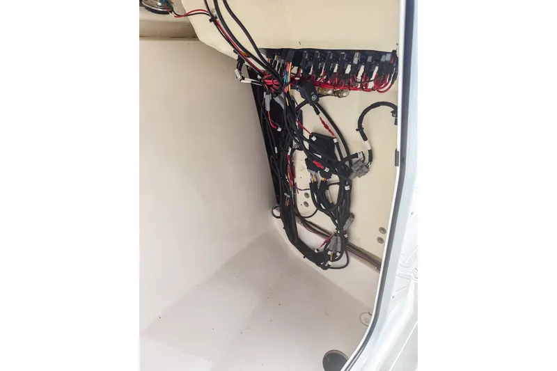 Slide: The Image of 2024 Aquasport AS DC 22 boat wiring compartment with organized cables and connectors. - 21