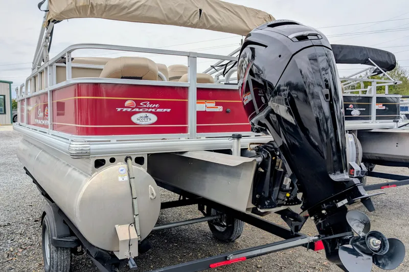 Slide: The Image of 2023 Sun Tracker Party Barge 18 pontoon boat with outboard motor, red and beige design. - 3