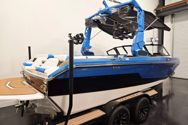 Slide: The Image of 2026 Nautique Super Air Nautique GS20 boat in showroom, featuring blue and white design. - 3