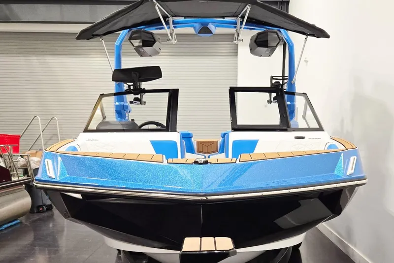 Slide: The Image of 2026 Nautique Super Air Nautique GS20 boat, blue and black, in showroom setting. - 4